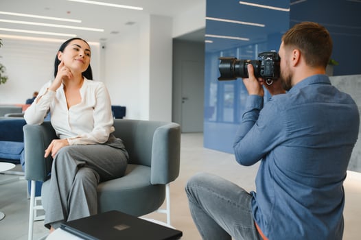 Male photographer taking picture of young woman photo