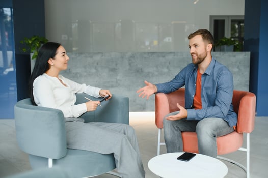 Business concept. Young dark-haired woman sitting in front of mature cheerful office manager on job interview, having relaxing talk about her experience and study degree. photo