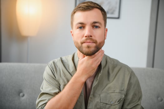 Sore throat. Dark-haired young man having a sore throat. photo