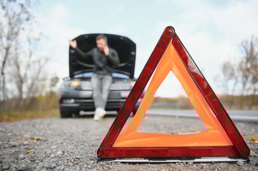 Handsome young man calling for assistance with his car broken down by the roadside photo