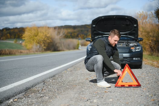 A young man with a black car that broke down on the road,copy space. photo
