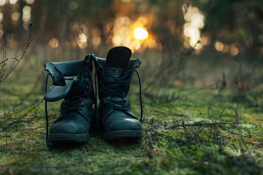 hiker old black boots standing on grass Hard travel concept photo