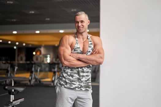 Muscular athletic bodybuilder fitness model standing gym photo