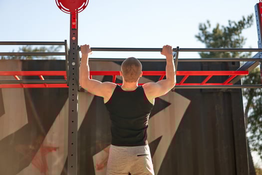 Unrecognizable caucasian men pull-up outdoor workout cross training morning back view photo