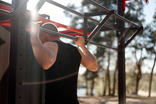 Unrecognizable caucasian men pull-up outdoor workout cross training morning back view photo