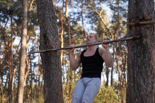 Handsome caucasian men pull-up outdoor workout cross training morning Pumping up arm exercising sports ground nature forest photo
