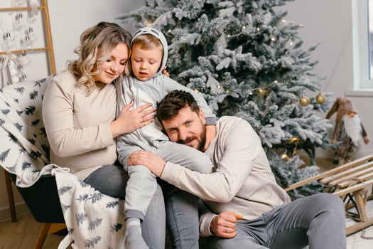 Christmas Family Happiness Portrait of dad, pregnant mom and little son  sitting armchair at home near Christmas tree hug smile photo