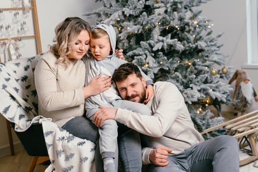 Christmas Family Happiness Portrait of dad, pregnant mom and little son  sitting armchair at home near Christmas tree hug smile photo