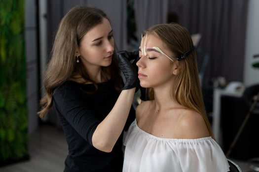 Young beautician caucasian girl holds model eyebrow correction photo