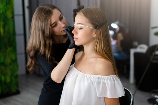 Young beautician caucasian girl holds model eyebrow correction photo