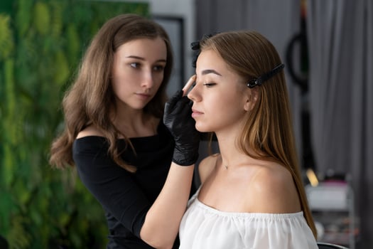 Young beautician caucasian girl holds model eyebrow correction photo