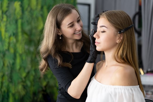 Young beautician caucasian girl holds model eyebrow correction photo