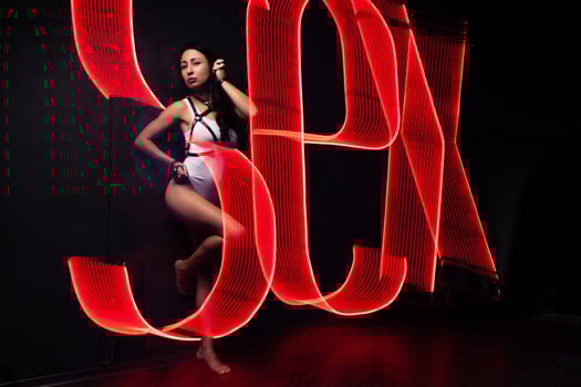 Hot sexy girl neon light dance night club concept dressed white night-club. Perfect female body with neon lettering on the background. Seductive female indoor photo