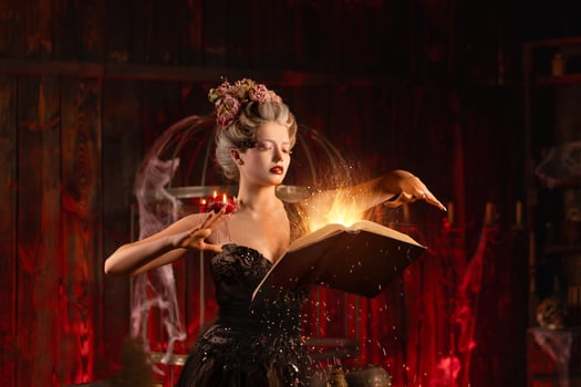 Charming woman witch flowers in hair vintage black dress with book of spell in the old castle. Halloween. Celebration. photo