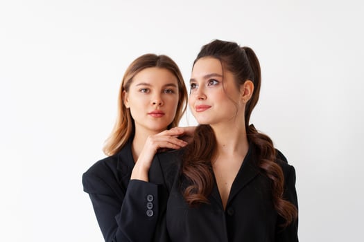 Concept of partnership in business. Two Young businesswoman dressed black formal suit standing studio isolated white background. photo
