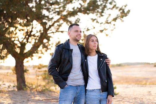 Happy and cute adorable adult couple of millennial hipsters, man with woman girlfriend walking, have fun play, laugh,smile and jump on sunset at desert photo