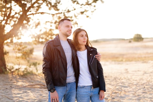 Happy and cute adorable adult couple of millennial hipsters, man with woman girlfriend walking, have fun play, laugh,smile and jump on sunset at desert photo