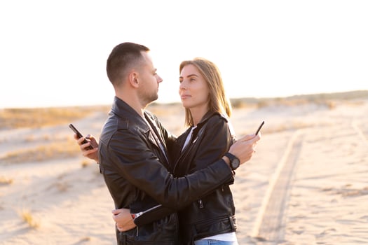Happy and cute adorable adult couple of millennial hipsters, man with woman girlfriend walking, have fun play, laugh,smile and jump on sunset at desert photo
