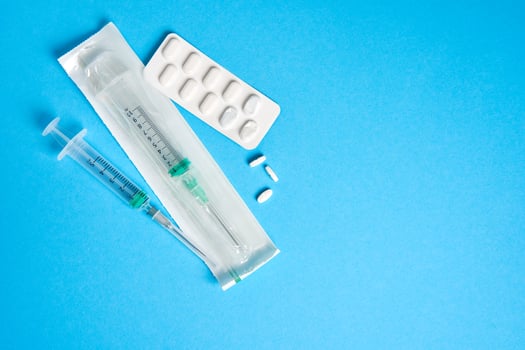 Empty used blisters from tablets silver and white color and pills lie on blue medical background photo