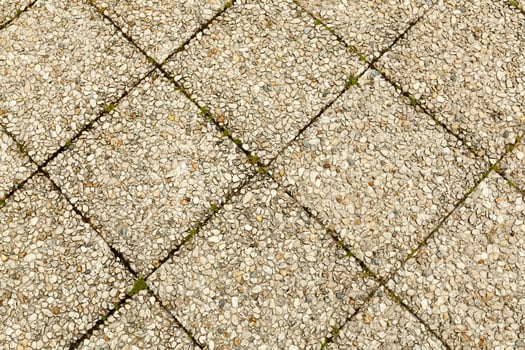 Pebble stone floor tile seamless background. Cement mixed gravel pebble stone floor texture. Wet round pebble stone rock floor in dramatic lighting. photo