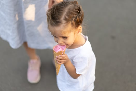 Little caucasian girl 3 years old eats ice cream closeup portrait photo
