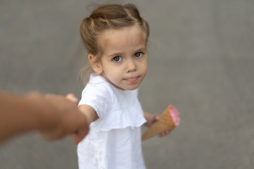 Little caucasian girl 3 years old eats ice cream closeup portrait photo