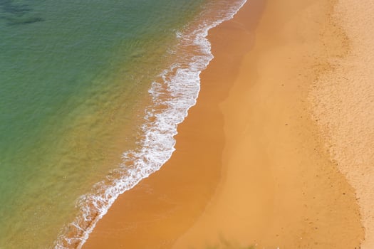 Aerial view of sea waves and sandy beach photo