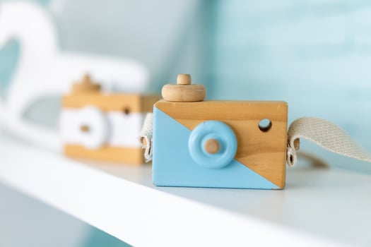 Toy wooden camera for children or decoration standing on shelf photo
