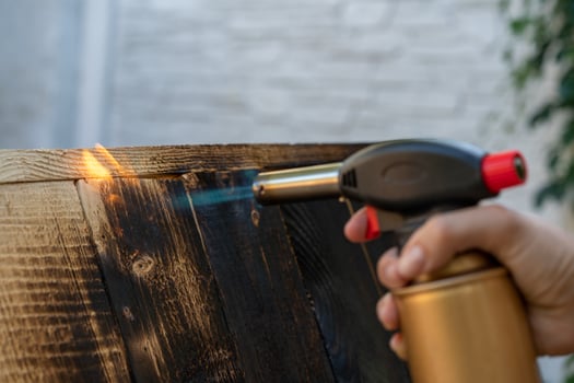 Professional carpenter using old traditional japanese technique. Burning wood planks with gas burner photo