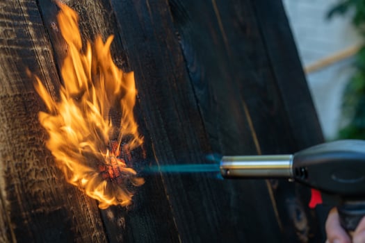 Professional carpenter using old traditional japanese technique. Burning wood planks with gas burner photo