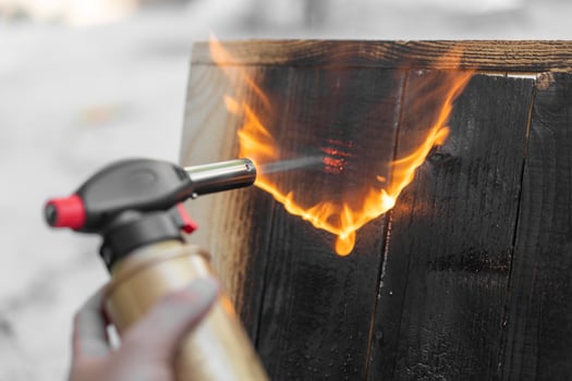 Professional carpenter using old traditional japanese technique. Burning wood planks with gas burner photo