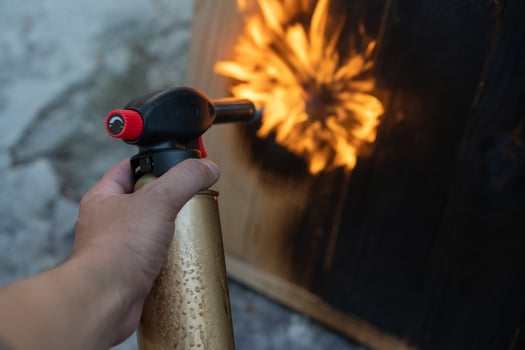Professional carpenter using old traditional japanese technique. Burning wood planks with gas burner photo