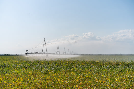 Irrigation System Watering Crops on Farm Field. photo