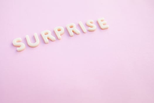 Surprise word written in voluminous white letters on a beautiful pink background. photo