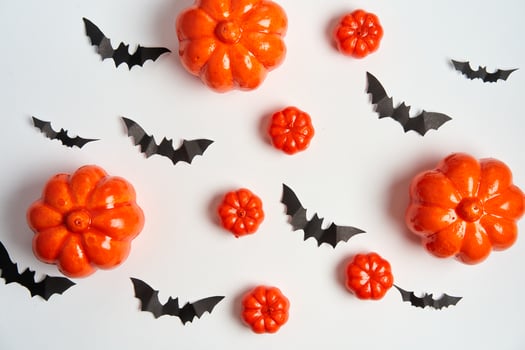 Halloween background, orange decorative plastic pumpkin black paper bat white cardboard Thanksgiving greeting card photo
