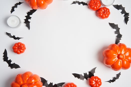 Halloween background, orange decorative plastic pumpkin black paper bat white cardboard Thanksgiving greeting card photo