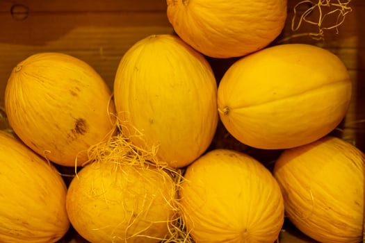 Juicy beautiful yellow melon lies in a cardboard box on the shelves of the store. photo