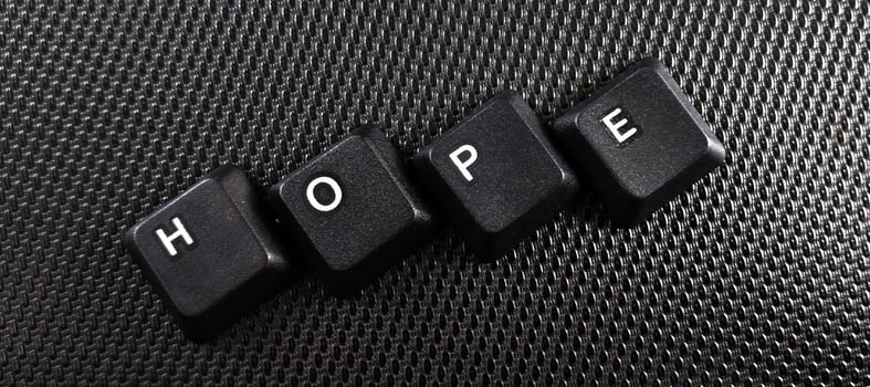 The word hope written with black computer keys on a black background. photo
