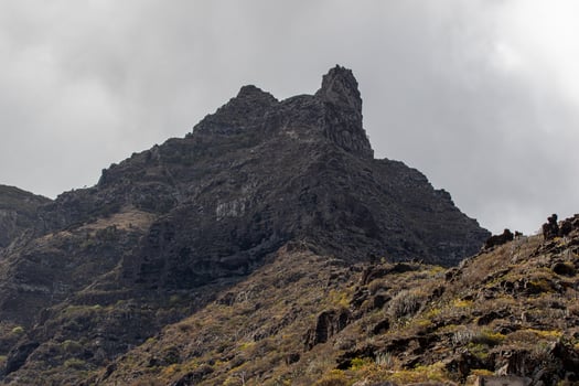 Dramatic rocky mountain peak against a cloudy sky Mountain landscape with blue sky and clouds in Tenerife. photo