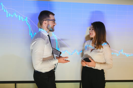 Portrait of two businessmen, a man and a woman in business clothes on the background of business graphs photo
