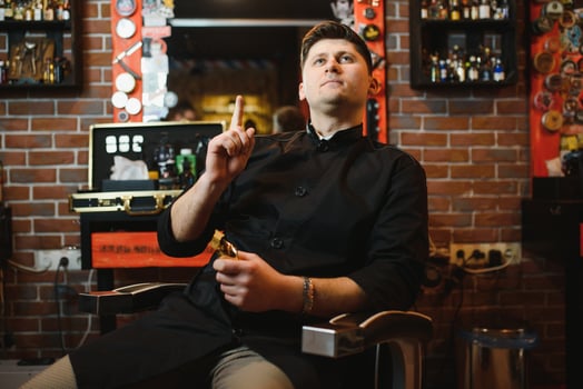 Portrait of handsome young man standing at barber shop. Stylish hairstylist standing in his salon with his arms crossed. photo