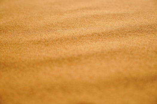 Sand grains arranged wavy in the desert, close-up photo