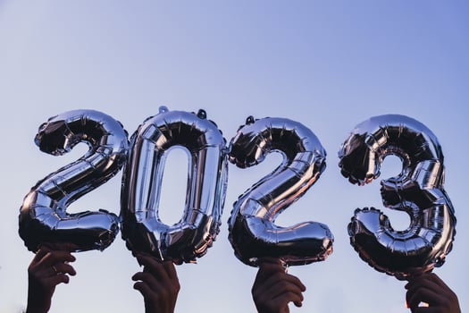 Silver foil number 2023 celebration new year balloon on blue sky background. Happy New year greetings concept. Hands holding balloons two thousand twenty-fourth year Christmas holiday concept photo