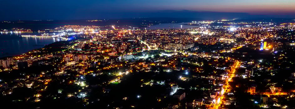 A panoramic aerial view of the city near the sea at night. photo
