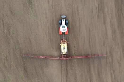 Top view of tractor spraying grain on a field. photo