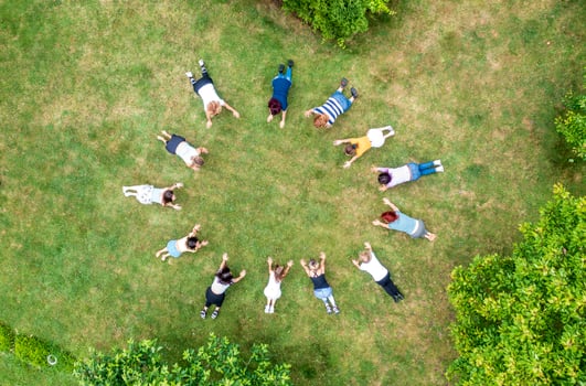 Top aerial view of people standing in circle on green grass. photo