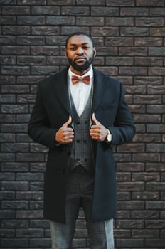 Fashion portrait of a handsome young African American business man walking outdoors in a casual pose. photo