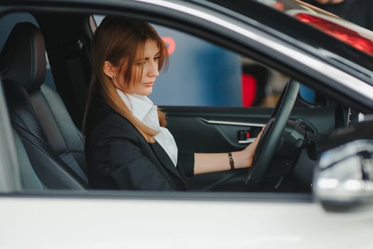 Photo of happy young woman sitting inside her new car. Concept for car rental.