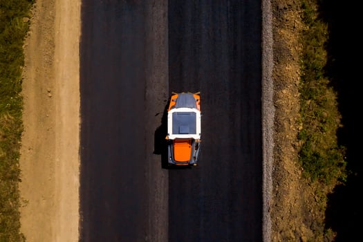 Heavy Vibration roller at work paving asphalt, road repairing. road roller flattening new asphalt. Aerial view photo
