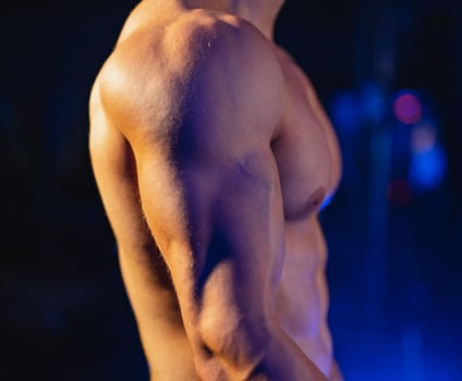Muscular male torso on black background. Selective focus. Strong abs, bodybuilder man. naked torso. Closeup. photo